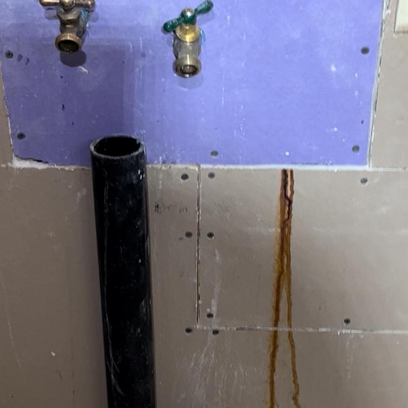 Hose bibbs and drywall with water stain from leak