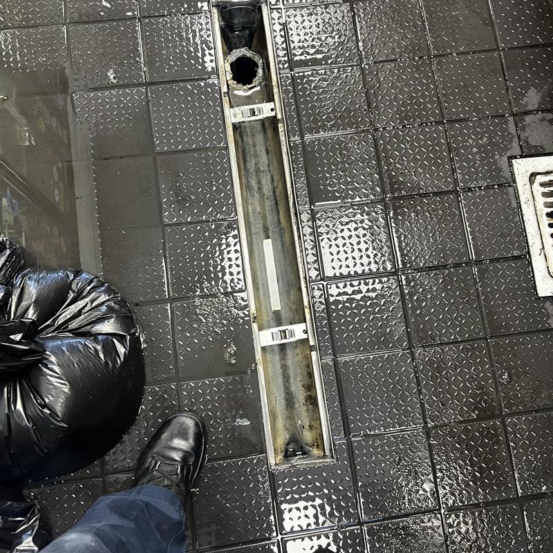 Trench drain channel open for cleaning on tiled floor