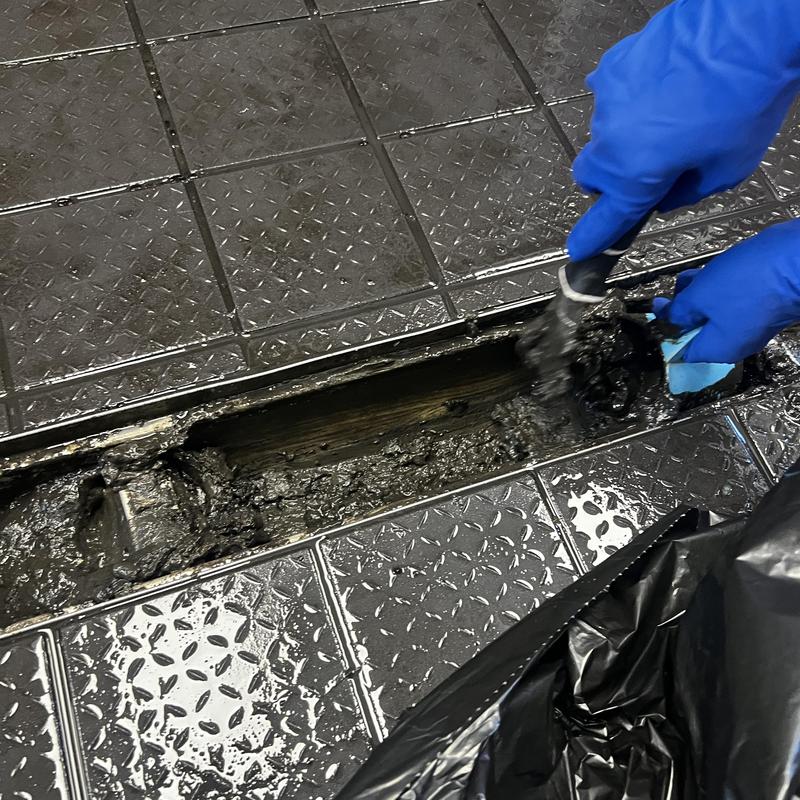 Trench drain cleaning with mud removal on tiled floor