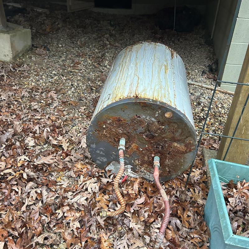 Electric water heater tank removed, rusted bottom panel