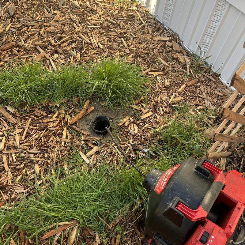 Sewer cleanout with cable machine clearing clog