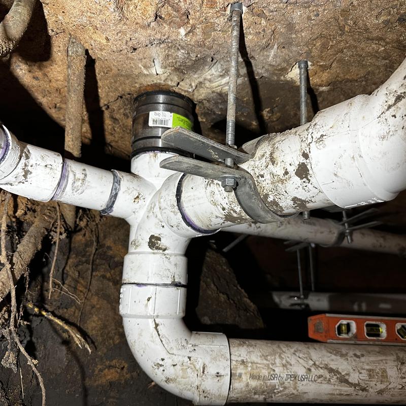 Schedule 40 PVC drain pipe with hangers in crawlspace