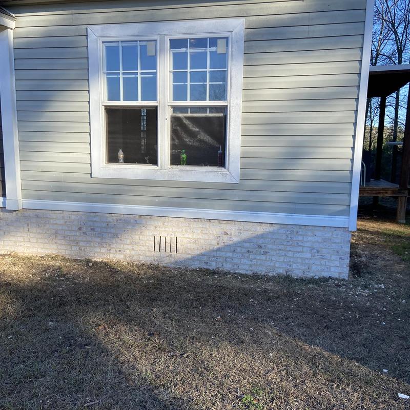 Brick skirting installation under mobile home exterior wall Brick skirting installation under mobile home exterior wall