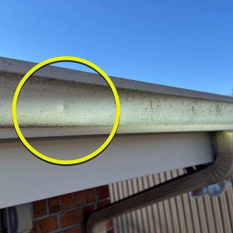 Metal roof drip edge with hail damage and corrosion