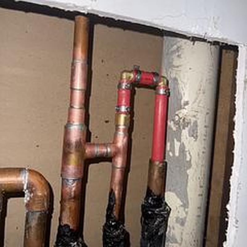 Copper and PEX hot water pipes with wall access opening