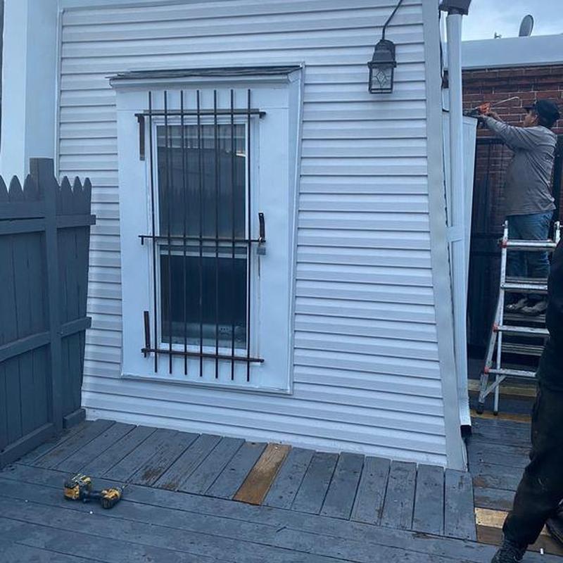 Vinyl siding installation with window and security bars