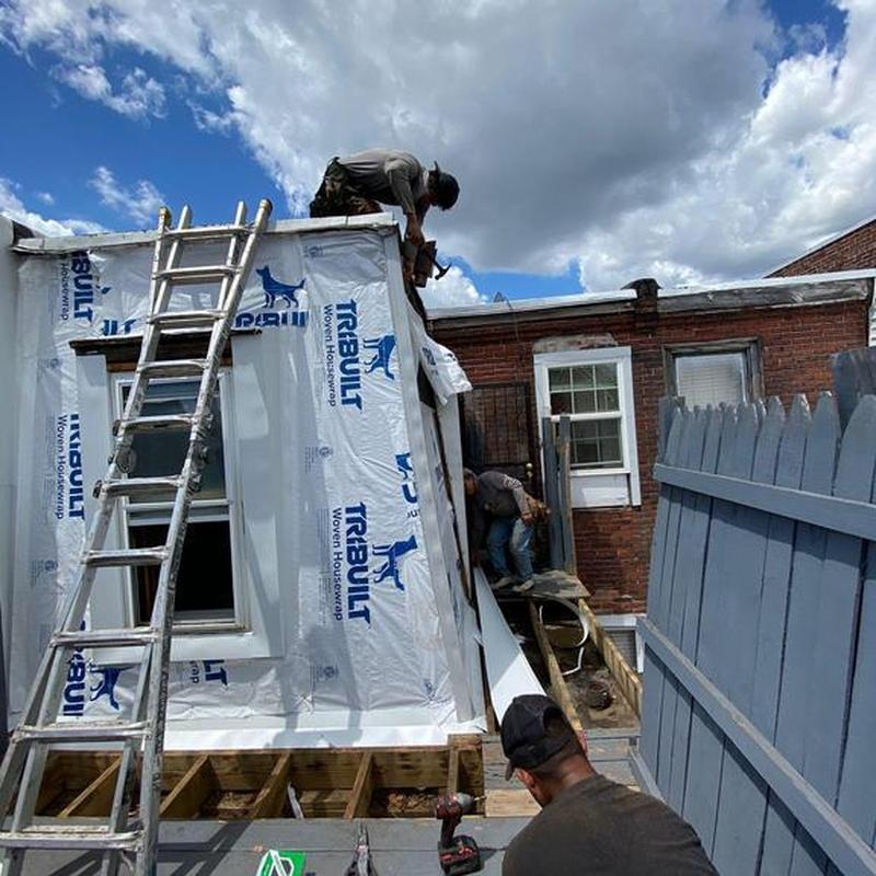 Vinyl siding installation with housewrap and ladder