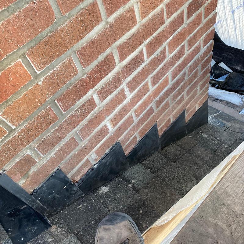 Chimney flashing installation on asphalt roof shingles Chimney flashing installation on asphalt roof shingles