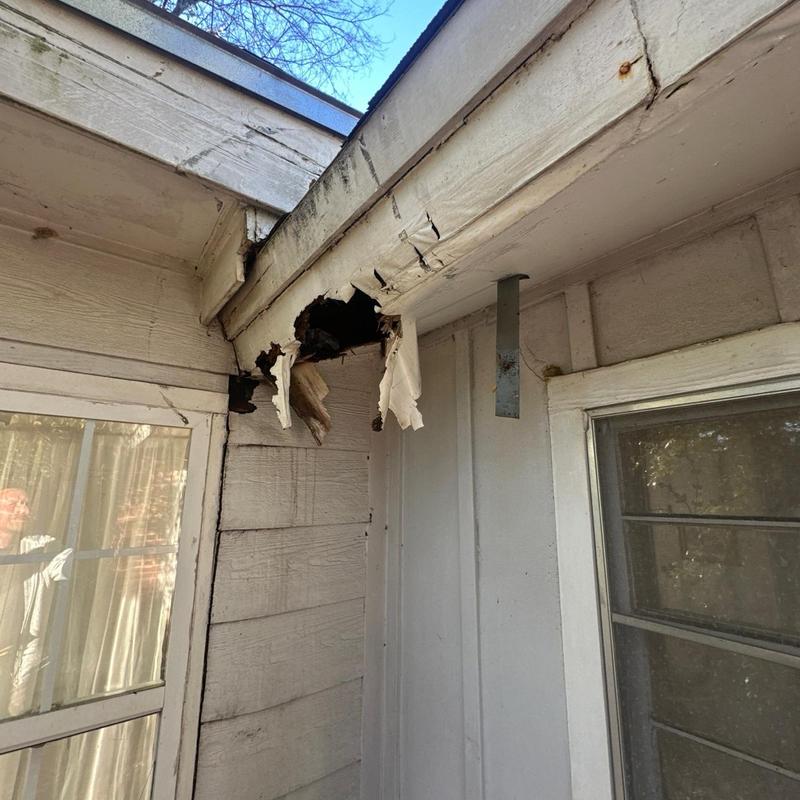 Soffit with water damage and wood rot hole