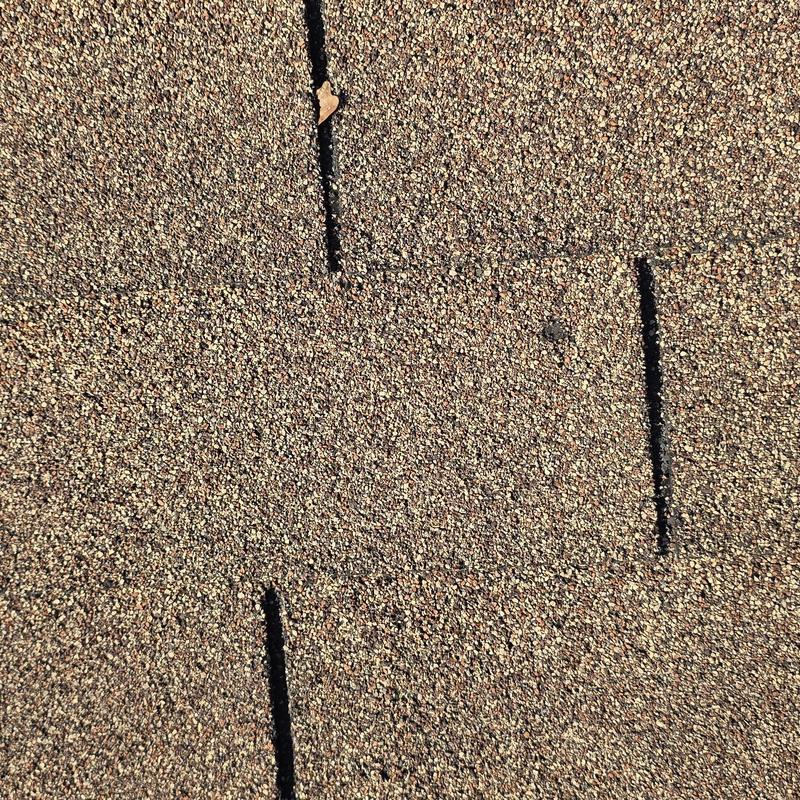 Asphalt shingle roof cracks marked for inspection