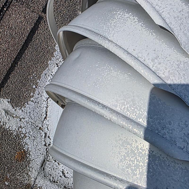 Metal roof vent with hail and wind damage signs