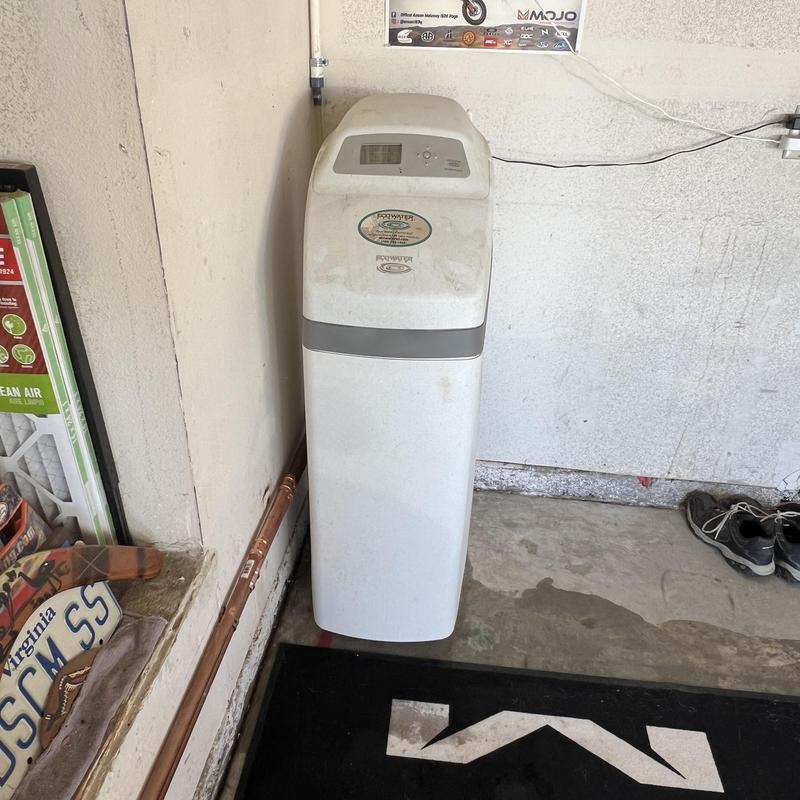 Water softener unit in garage corner
