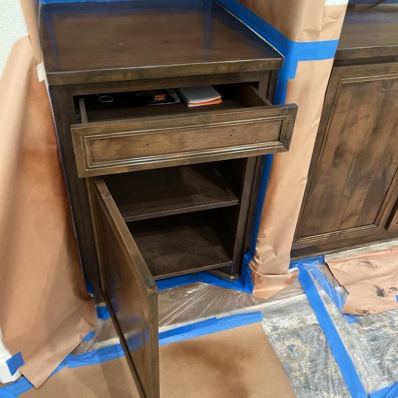 Stained wooden cabinet with open drawer and door