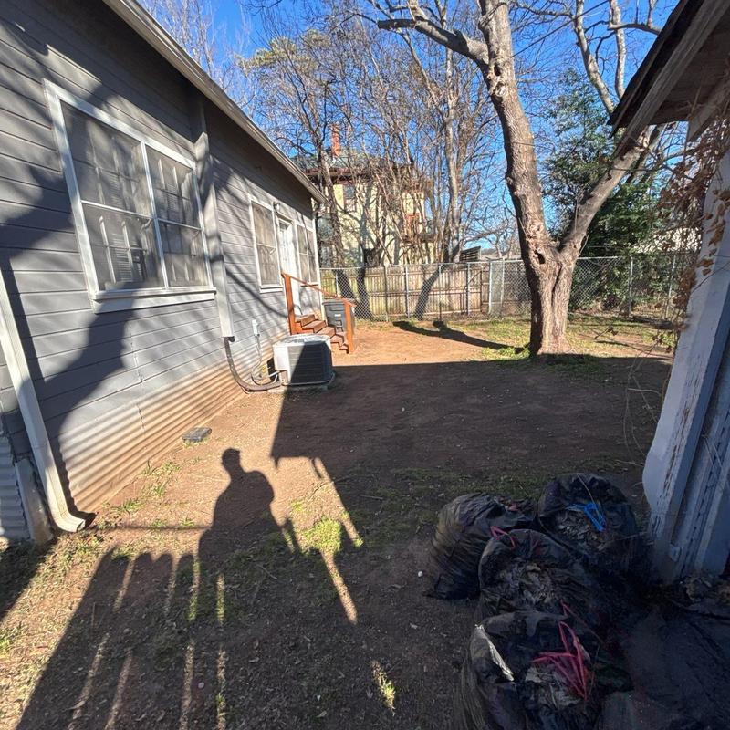 Tree trimming near house and yard cleanup bags