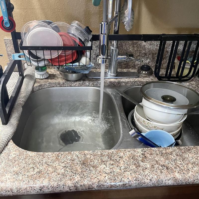 Kitchen sink with running faucet and dish rack