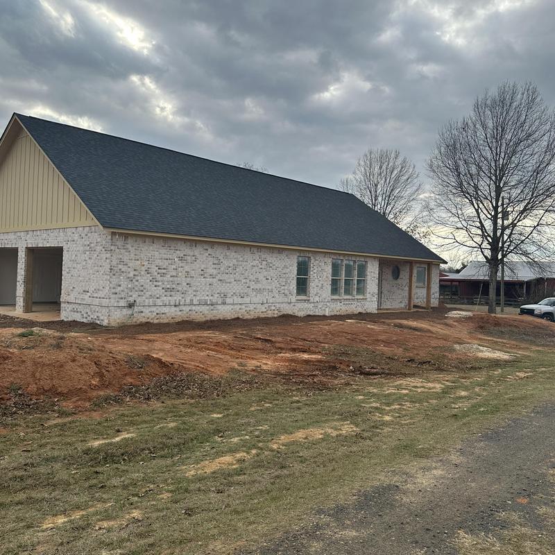 New shingle roof on brick house construction site New shingle roof on brick house construction site