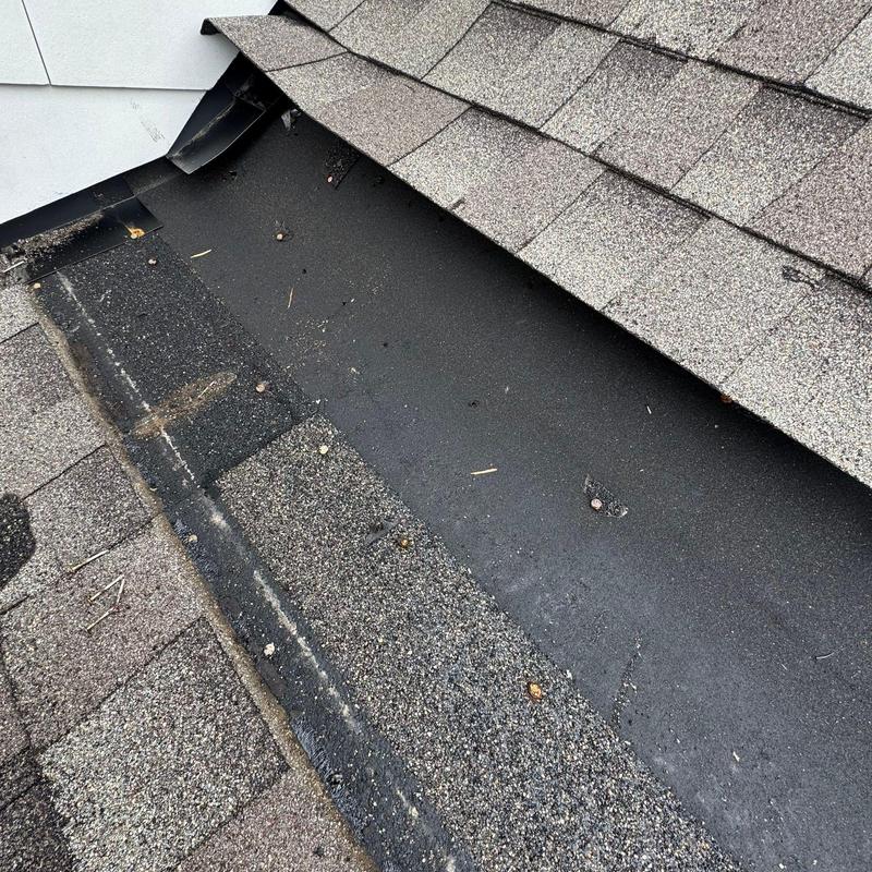 Asphalt shingle roof with valley flashing and hail damage