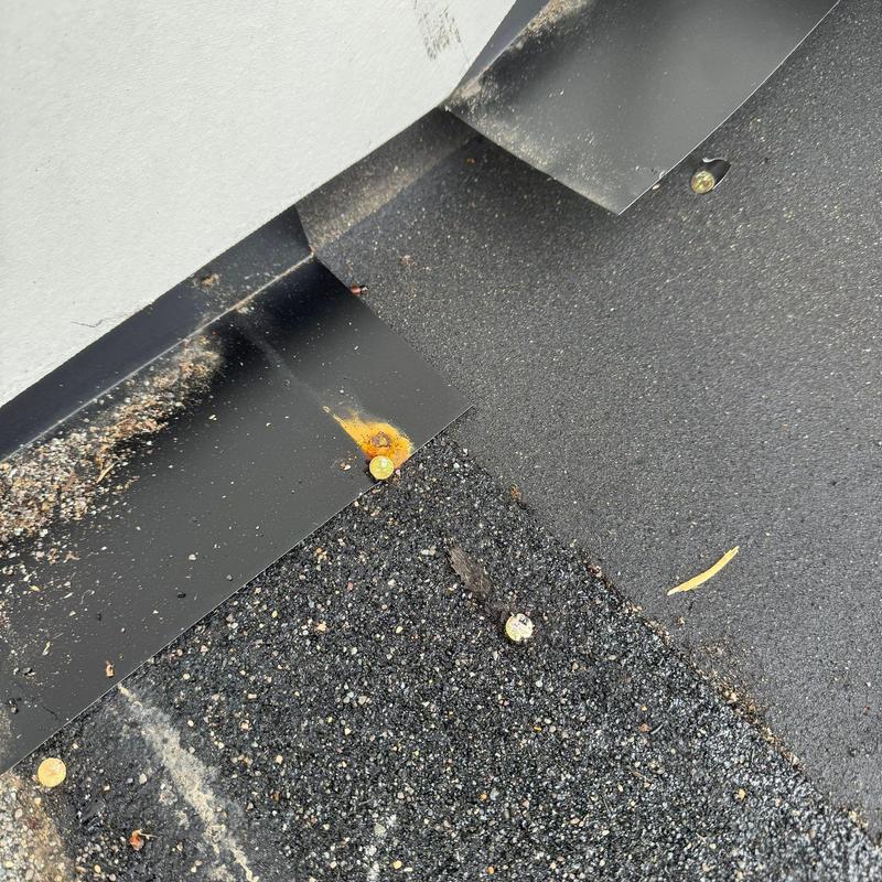 Roof flashing with rust and worn shingles detail
