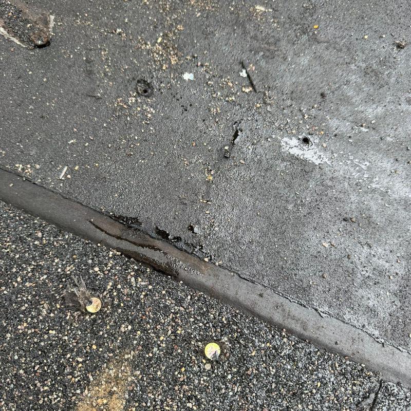 Asphalt shingle roof with hail damage near flashing edge