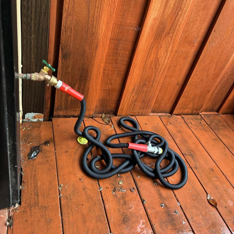 12 hose bib with attached garden hose on wooden deck