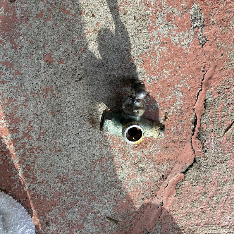 Exterior hose bib valve removed from wall surface