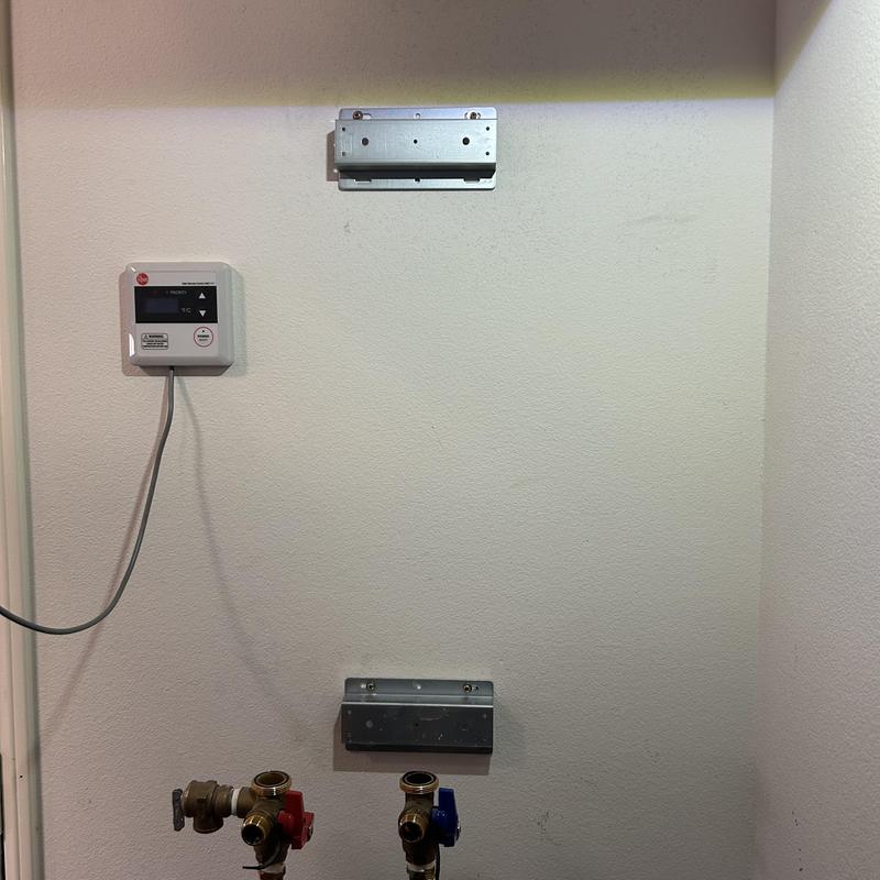 Tankless water heater brackets and valve connections on wall