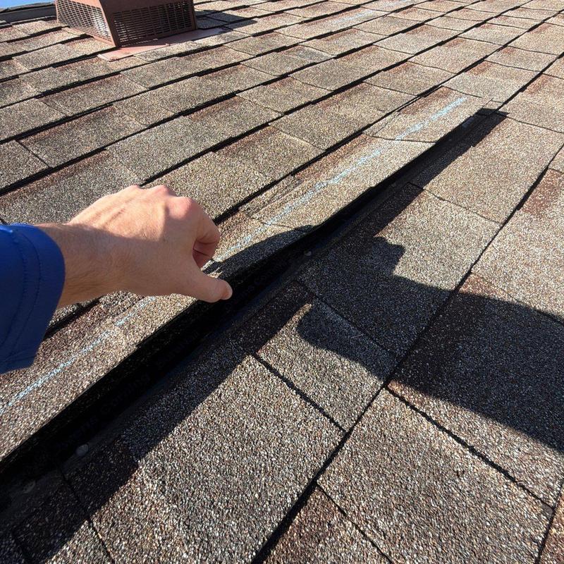 Asphalt shingle roof with lifted damaged shingle gap Asphalt shingle roof with lifted damaged shingle gap