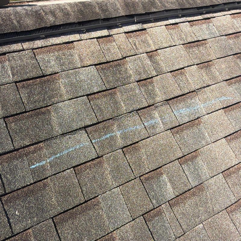 Asphalt shingle roof with chalked damage line Asphalt shingle roof with chalked damage line