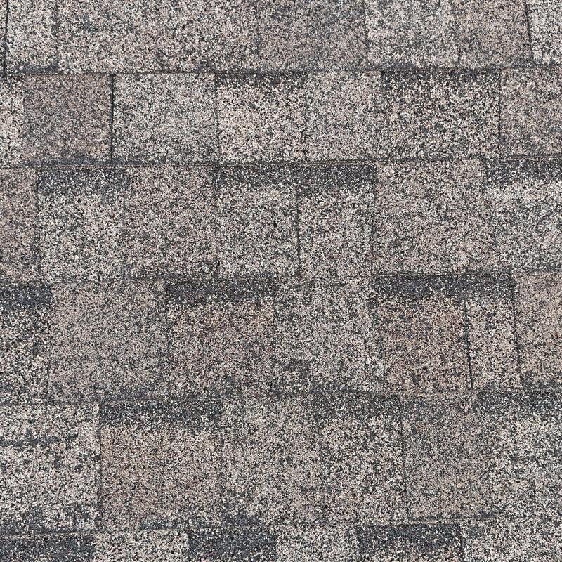 Asphalt roof shingles with visible hail damage and wear