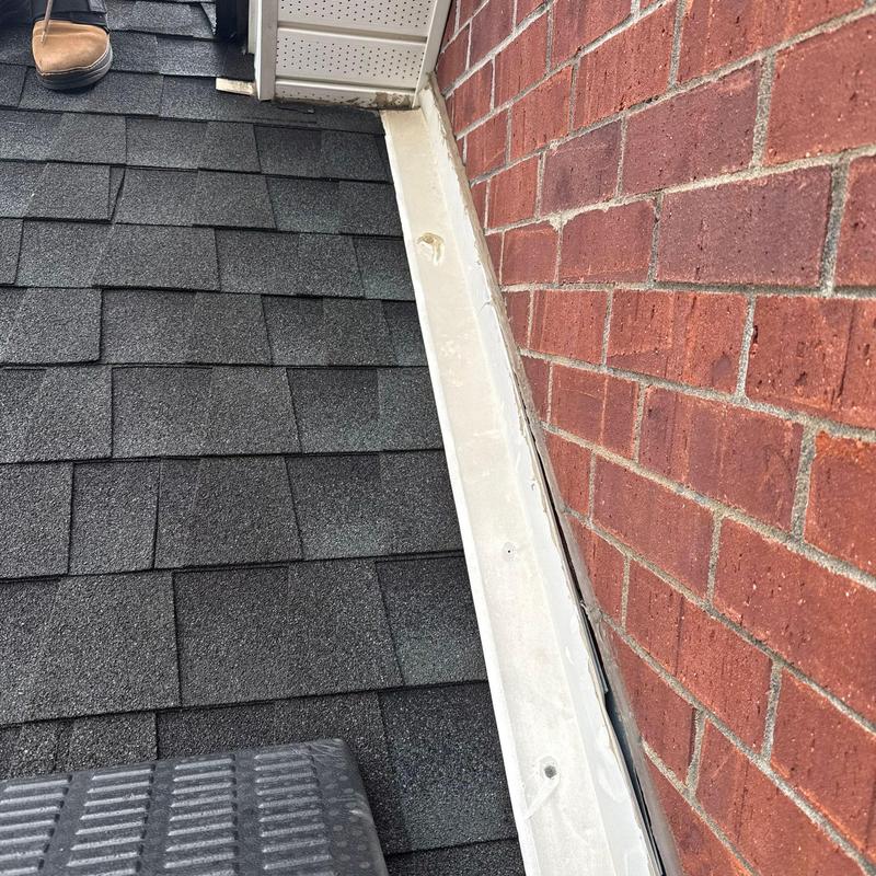 Roof flashing along brick wall and shingle roof
