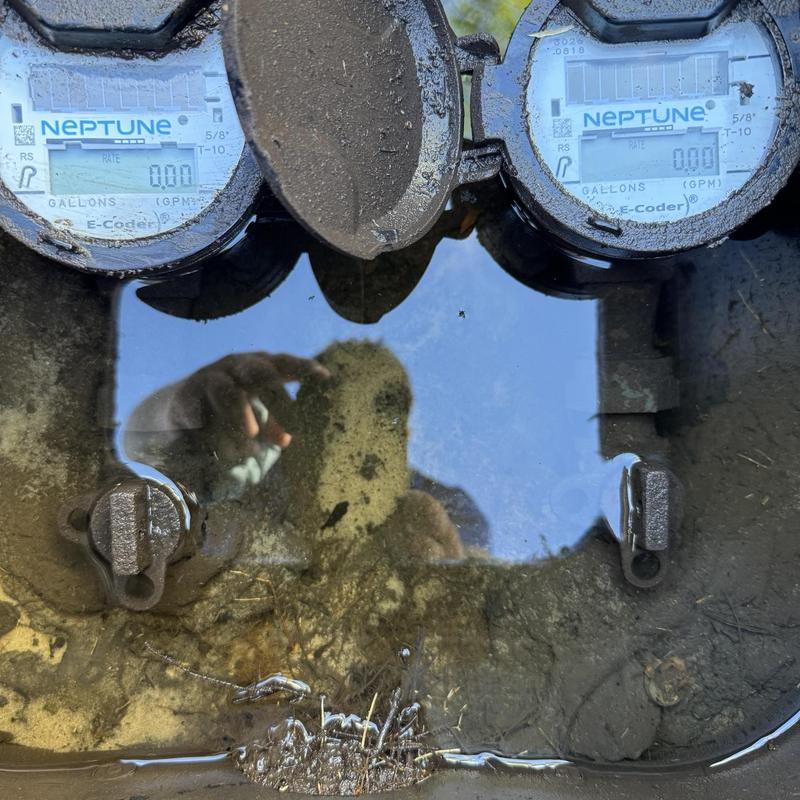 Water meter box with standing water and open lids