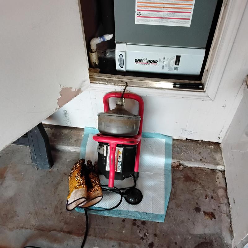 AC drain cleaning machine and gloves near HVAC unit