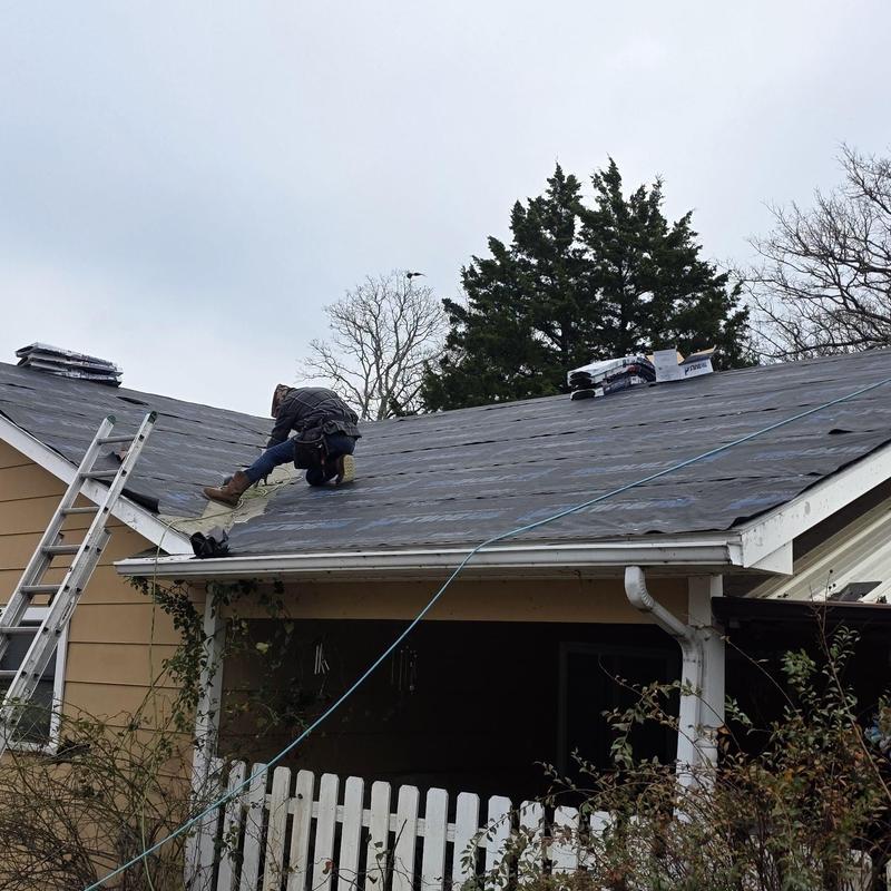 Roof underlayment installation with shingles staged on roof