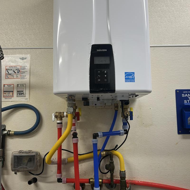 Tankless water heater with connected red and blue pipes