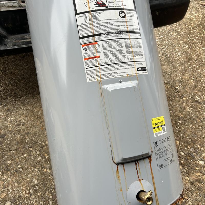 Water heater with rust stains outside building