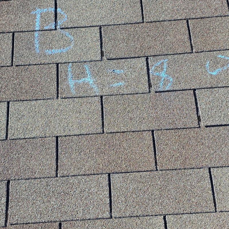 Asphalt shingles with chalk markings for hail damage
