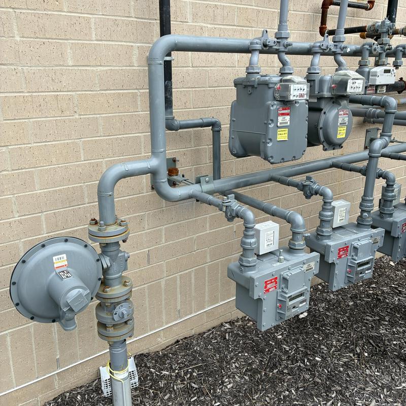 Gas meter and regulator setup against brick wall