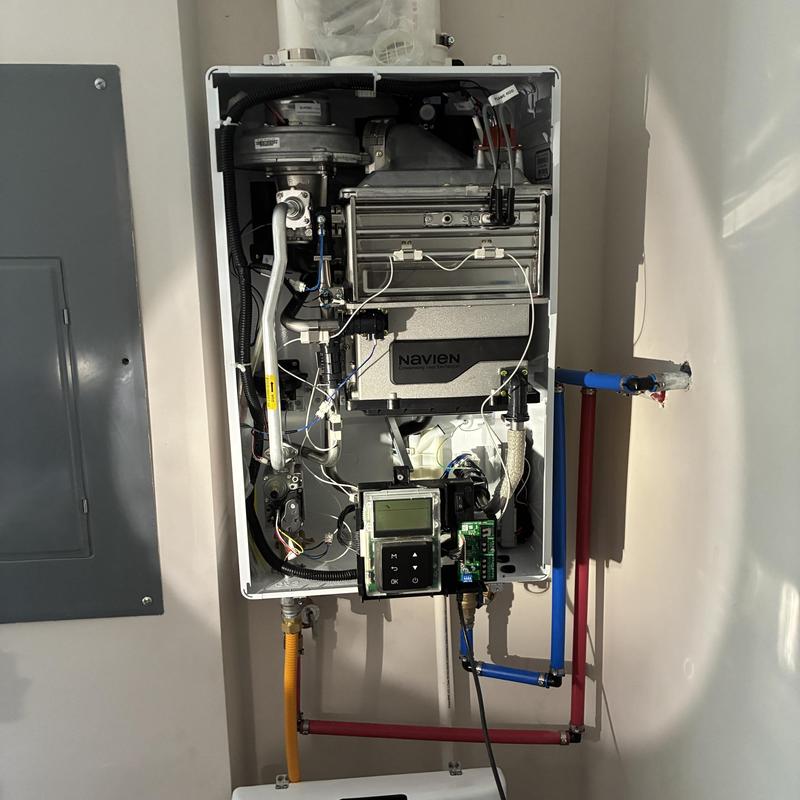 Tankless water heater unit with internal components exposed