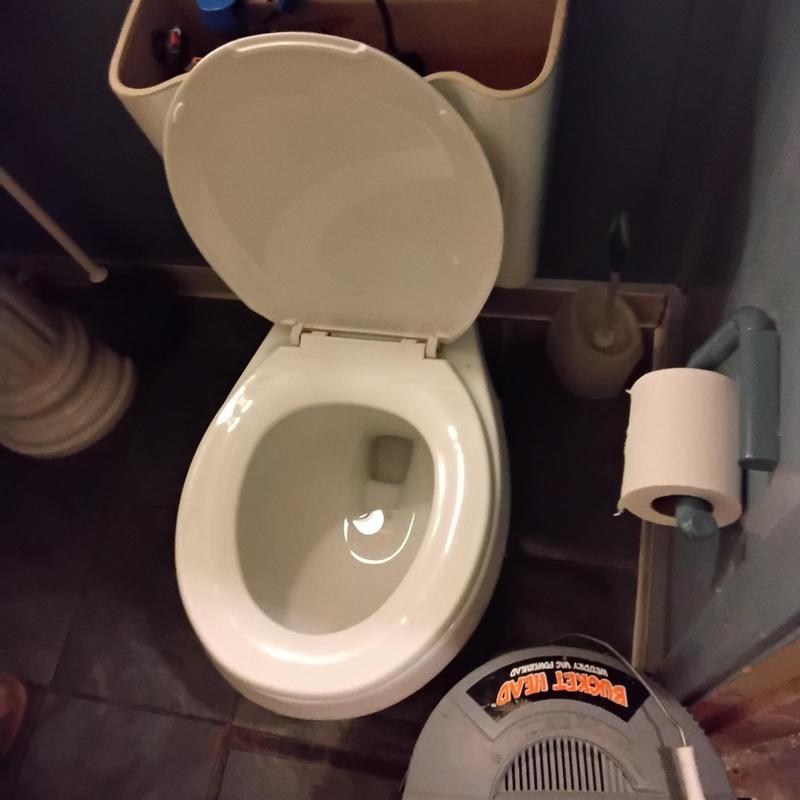 Hallway bathroom toilet with removed tank for stoppage access