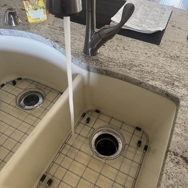 Kitchen faucet with flowing water and sink grate