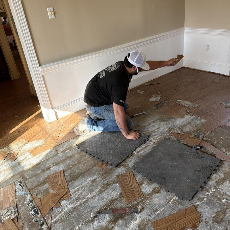 Old hardwood floor removal with tools and debris Old hardwood floor removal with tools and debris