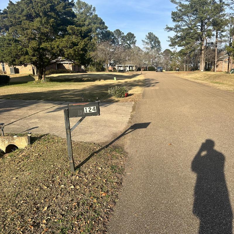 Mailbox post with house number 124 near street curb