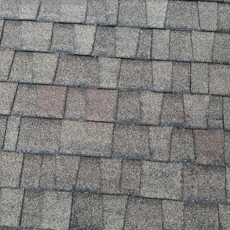 Asphalt shingles roof surface close-up with wear signs