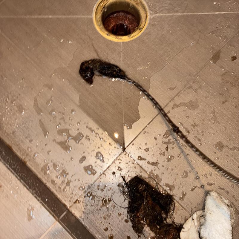 Shower drain clog removal with cable and debris cleaning