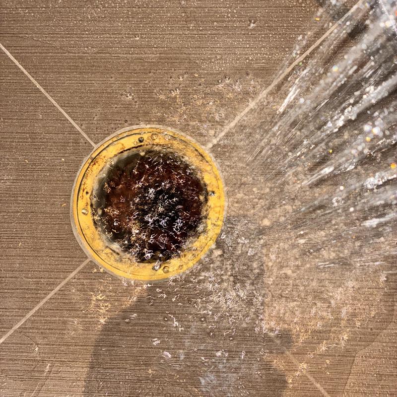 Brass shower drain cover with flowing water