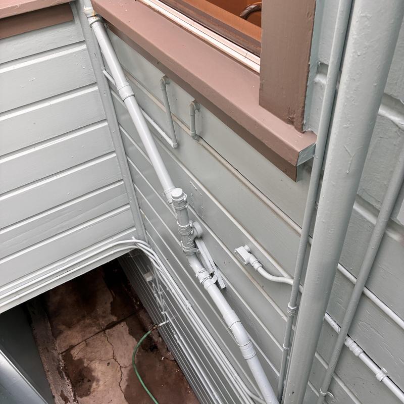 Exterior drainpipe paint touch-up on side of house