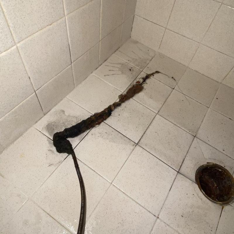 Shower drain clog cleared with hand crank snake