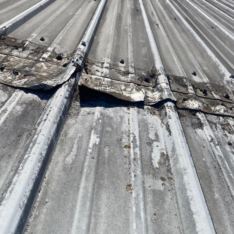 Metal roof panels with rust and damage close-up