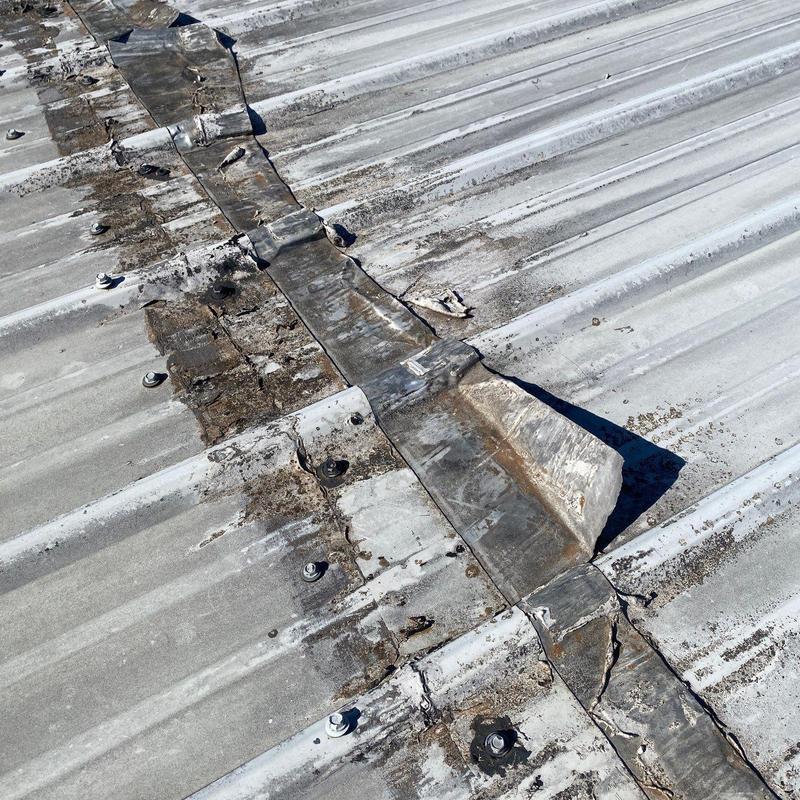 Metal roof ridge flashing with weather damage