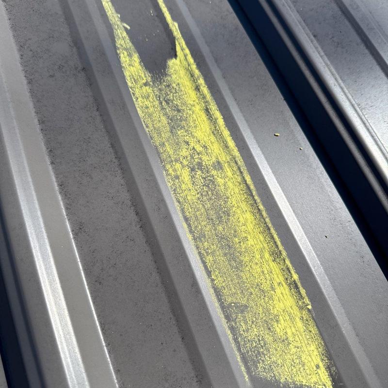 Metal roof panel with hail damage markings